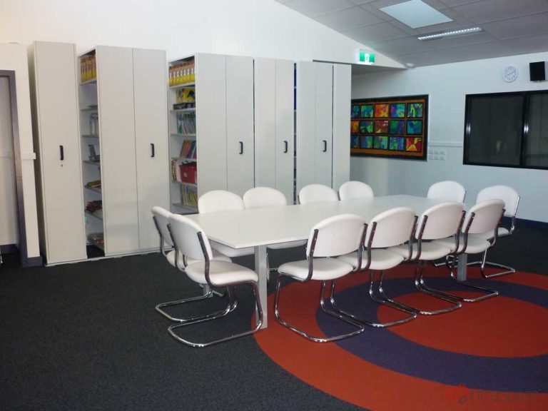 Interior photo of meeting table and mobile shelving in Lethbridge Primary School as installed by IntraSpace.